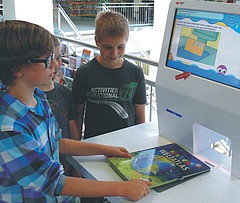 Kinder leihen ein Buch an einem Selbstbedienungsterminal aus